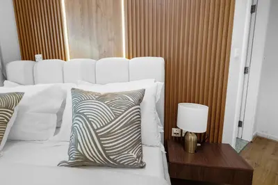 a bed with a pillow and a nightstand with a lamp at Elegant Haven and Spacious 2BR in Lake Terrace in Dubai