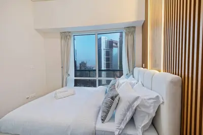 a bedroom with a large white bed with a window at Elegant Haven and Spacious 2BR in Lake Terrace in Dubai
