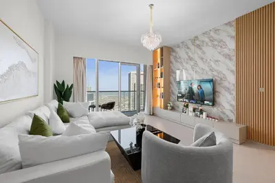 a living room with white furniture and a tv at Luxury 2BR Apartment in Downtown Dubai in Dubai