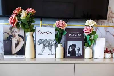 a shelf with vases with books and flowers on it at Luxury 2BR Apartment in Downtown Dubai in Dubai