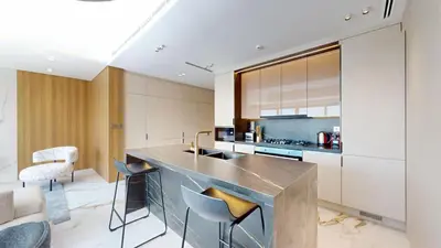 a kitchen with a counter and chairs in a room at Jumeirah Golf Estate - Elegant Three Bed Villa in Dubai