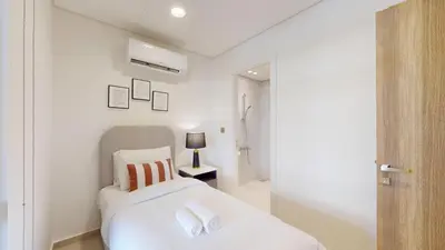 a white bedroom with a bed and a lamp at Jumeirah Golf Estate - Elegant Three Bed Villa in Dubai