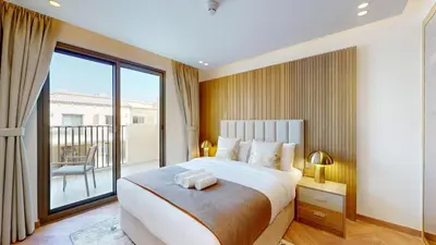 a bedroom with a large bed and a large window at Jumeirah Golf Estate - Elegant Three Bed Villa in Dubai