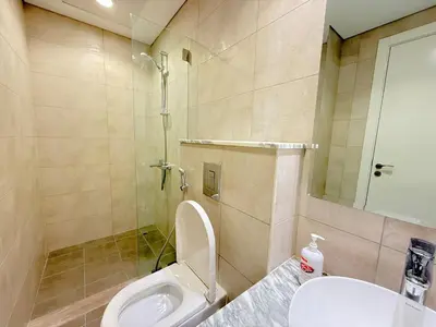 a bathroom with a toilet and a shower and a sink at Cozy Two Bedroom Apartment in Dubai