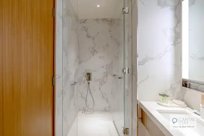 a bathroom with a shower and a toilet and a sink at Luxury 3BR Apartment with Burj Khalifa Views - Address Opera in Dubai