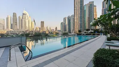 a swimming pool with a city skyline in the background at Lux 3 BR & Maidroom Burj & Fountain View 1Gbps WIFI in Dubai