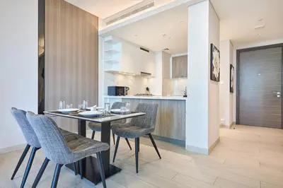 a dining room with a table and chairs and a kitchen at STAY BY LATINEM Luxury 1BR Holiday Home OPA2401 near Burj Khalifa in Dubai