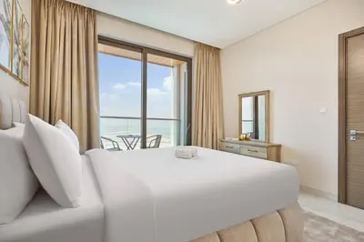 a bedroom with a large white bed and a large window at STAY BY LATINEM Luxury 1BR Holiday Home OPA2401 near Burj Khalifa in Dubai