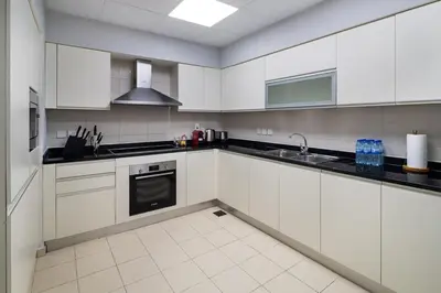 a kitchen with white cabinets and a sink at 4BR Oceana Residences - Beach and Pool Access in Dubai