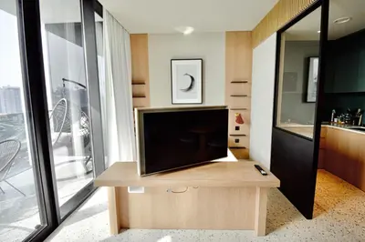 a living room with a television on a wooden table at Modern Studio at Upside Living, Business Bay with Burj Khalifa View in Dubai