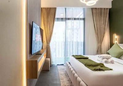 a hotel room with a bed and a flat screen tv at Royal Vista - Luxury 1BR Apartments at Kensington Waters in Dubai