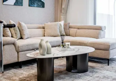 a living room with a couch and a coffee table at Royal Vista - Luxury 1BR Apartments at Kensington Waters in Dubai