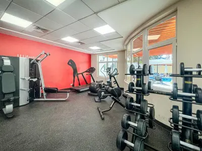 a gym with several treadmills and machines in a room at Air Homes - Stylish Urban Living in a Modern 1BR in Dubai