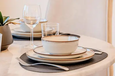 a table with plates and wine glasses and a bowl at 1BD in Ocean Heights, Dubai Marina for 4 Guests in Dubai