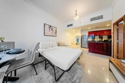 a kitchen and dining room with a white table and chairs at 1BD in Ocean Heights, Dubai Marina for 4 Guests in Dubai