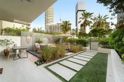 a garden with a patio with a table and chairs at Garden Hideaway 2BR Boho Duplex Resort Living in Dubai