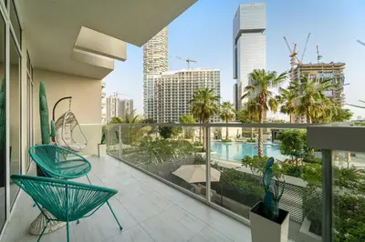 a balcony with chairs and a view of a city at Garden Hideaway 2BR Boho Duplex Resort Living in Dubai