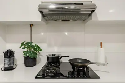 a stove top with a pot and a pan on it at Garden Hideaway 2BR Boho Duplex Resort Living in Dubai