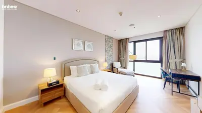 a hotel room with a bed and a desk with a desk at bnbme - Luxury Anantara Palm Apt Beachfront Lagoon Pools Balcony & Spa Access in Dubai