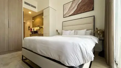 a bedroom with a large bed with white sheets at Bespoke Holiday Homes - Studio with Modern Amenities in Azizi Riviera in Dubai