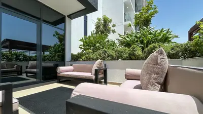 a patio with couches and chairs on a building at Bespoke Holiday Homes - Studio with Modern Amenities in Azizi Riviera in Dubai
