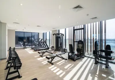 a gym with treadmills and cardio equipment in a building at Bespoke Holiday Homes - Studio with Modern Amenities in Azizi Riviera in Dubai