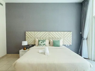 a bedroom with a large bed with a teddy bear on it at Nivis find- Luxury 1 BHK nearby Dubai Mall in Dubai
