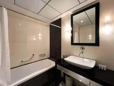 a bathroom with a sink and a tub and a mirror at Luxury 2BR with Contemporary Design & Great Views in Dubai