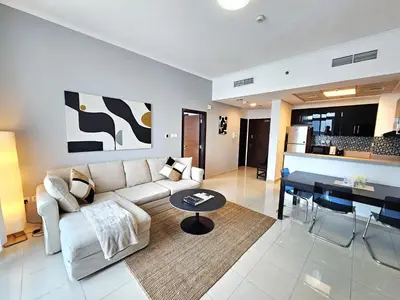 a living room with a couch and a table at SUNRISE HOMES - Charming 1-BR Just a walk to JBR Beach in Dubai