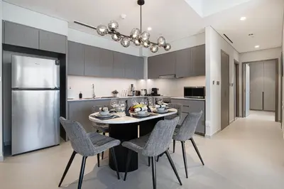 a kitchen with a table and chairs and a refrigerator at Luxury 2BR Burj Fountain View Walk to Dubai Mall in Dubai