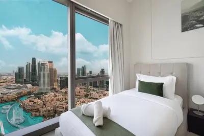 a bedroom with a bed and a large window at Luxury 2BR Burj Fountain View Walk to Dubai Mall in Dubai