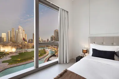 a bedroom with a large window with a view of a city at 2BR Walk to Burj Mall & Opera Pool View in Dubai