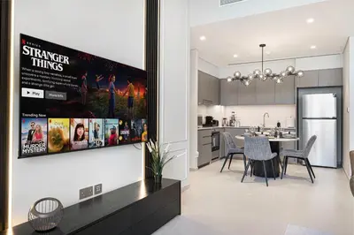 a kitchen and dining room with a movie poster on the wall at 2BR Walk to Burj Mall & Opera Pool View in Dubai