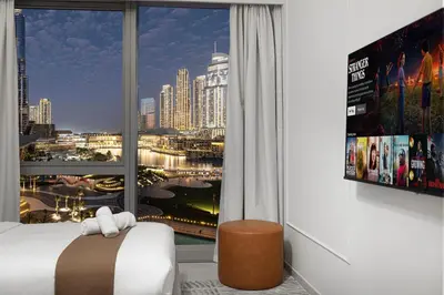 a bedroom with a large window with a view of a city at 2BR Walk to Burj Mall & Opera Pool View in Dubai