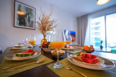 a table with plates of food and glasses of orange juice at Modern 1BR 4 Guests Dubai World Trade Center in Dubai