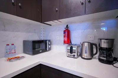a kitchen counter with a microwave and a coffee maker at Modern 1BR 4 Guests Dubai World Trade Center in Dubai
