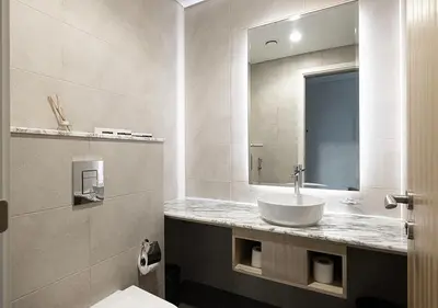 a bathroom with a sink and a mirror at Paramount Midtown Hotel - Luxury Apartments & Infinity Pool with Burj Khalifa View in Dubai