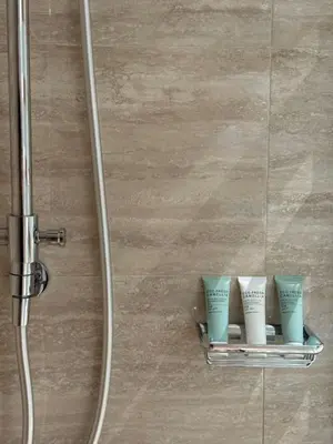 a shelf in a shower with three cups on it at Stylish 2BR - Burj Khalifa - Waterfront View - Fully Furnished in Dubai