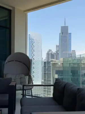 a living room with a couch and a large window at Stylish 2BR - Burj Khalifa - Waterfront View - Fully Furnished in Dubai
