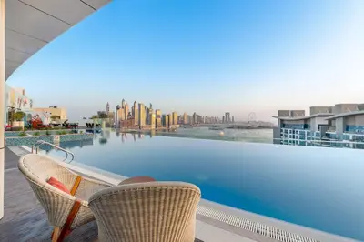 a view from the balcony of a hotel with a swimming pool at Serene Palm Studio - Rooftop Infinity Pool & Private Beach Access in Dubai