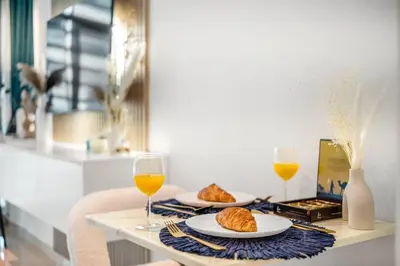 a table with two glasses of orange juice and croissants at Stunning Palm Studio - Rooftop Infinity Pool & Private Beach Access - MaxStays in Dubai