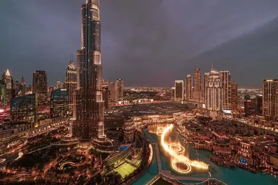 a city skyline at night with a tall skyscraper at Luxury 2BR Burj View Private Hot Tub Walk to DubaiMall in Dubai