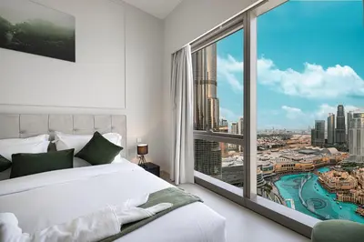 a bedroom with a white bed and a large window at Luxury 2BR Burj View Private Hot Tub Walk to DubaiMall in Dubai