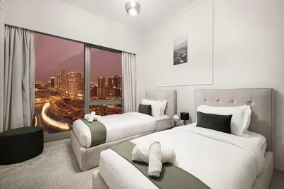 a hotel room with two beds and a large window at Luxury 2BR Burj View Private Hot Tub Walk to DubaiMall in Dubai