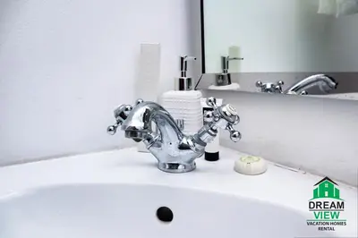 a bathroom sink with a faucet in front of a mirror at Souk AL Bahar Burj Khalifa View from main door, luxury Apartment, Dream view holiday homes in Dubai