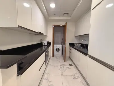 a white kitchen with a washing machine in it at Premium 1BR W Canal & Burj View in Al Habtoor City in Dubai
