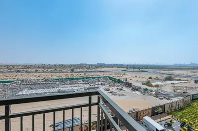 a view of a beach from the balcony of a resort at Waves - Stylish Blue Haven near Town Square Park in Dubai