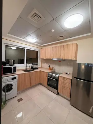 a kitchen with wooden cabinets and a stainless steel refrigerator at Stunning Park View 1Bhk 4pax in Dubai