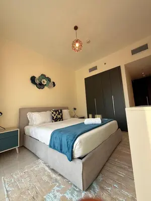 a bedroom with a large bed with a blue blanket at Stunning Park View 1Bhk 4pax in Dubai