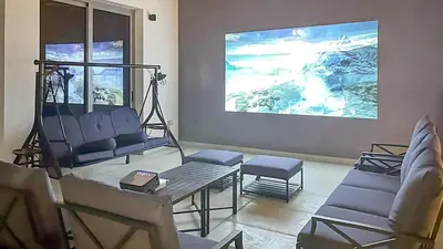 a living room with a couch and a table at Bright 2BR Retreat Balcony & Pool Near Jumeirah Village Circle in Dubai